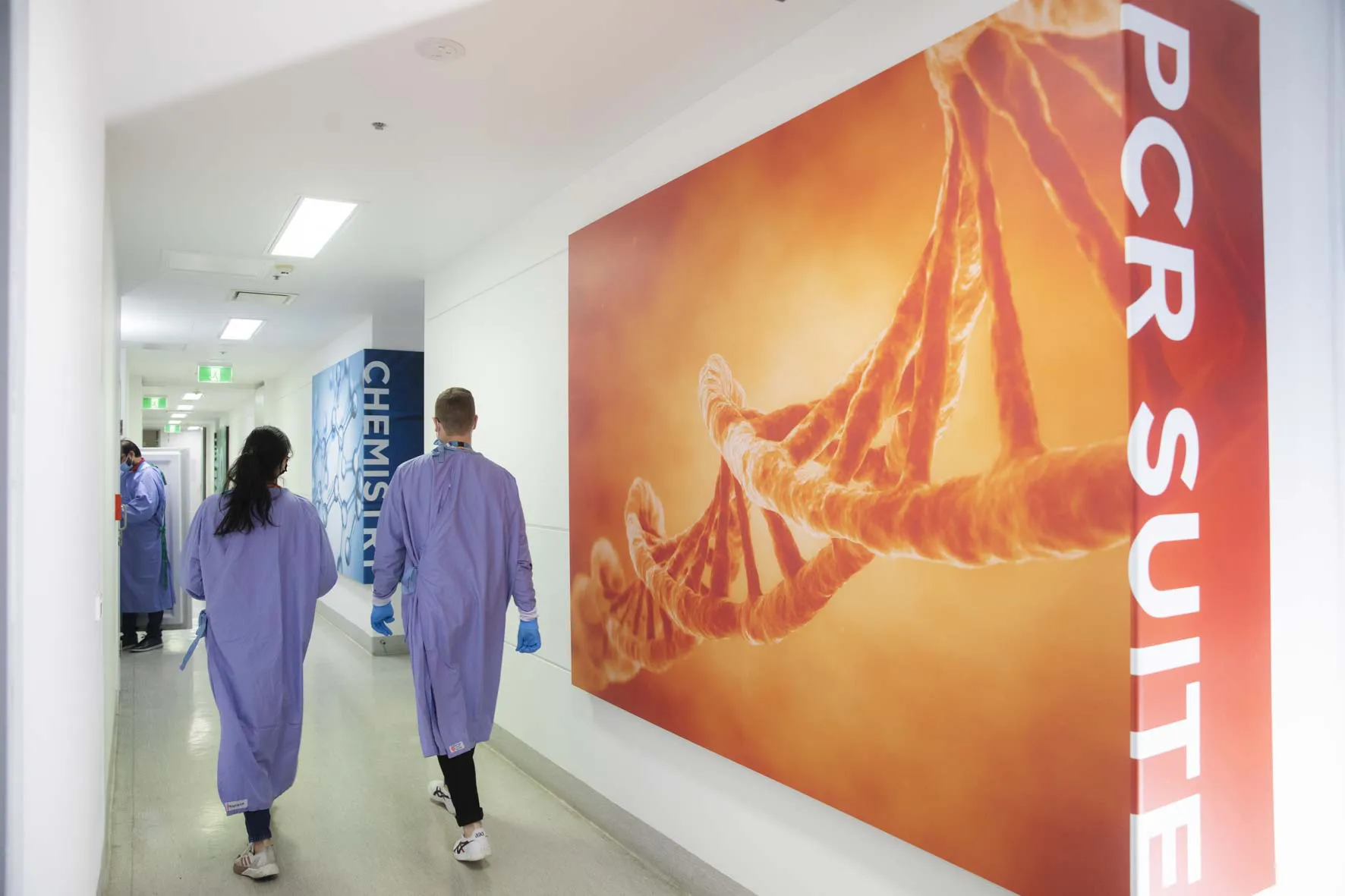 Scientists walking outside of state-of-the-art PCR Suite